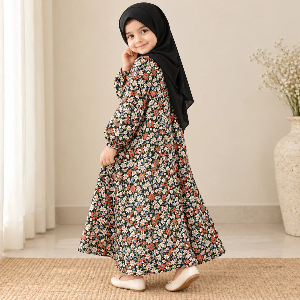 Girl wearing a dark abaya with tiny multicolour flowers, elastic cuffs and a flared hem, styled with a black hijab.
