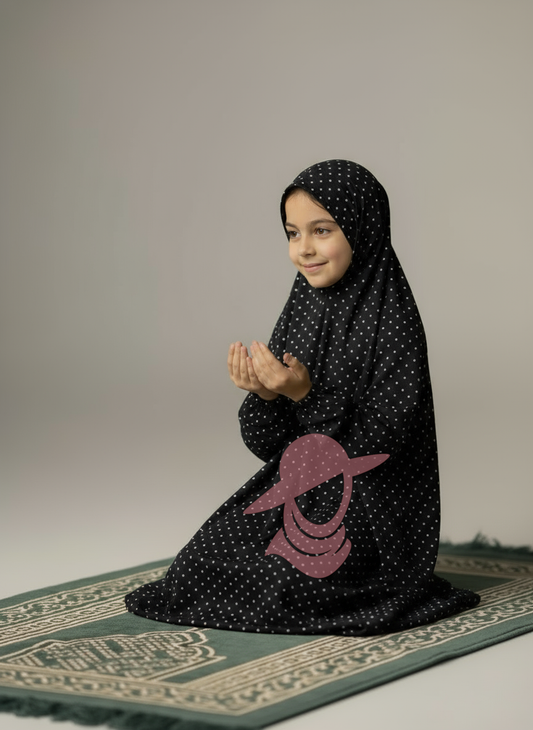 Black Polka Dot Kids Namaz Chaddar for girls, sitting on prayer mat, modest and comfortable
