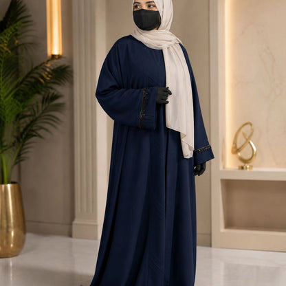 Model wearing premium navy closed nida abaya with attached inner and delicate lace sleeve detailing
