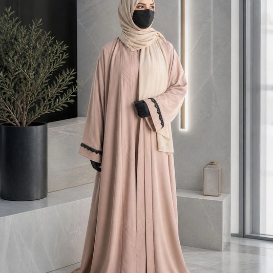 Model wearing premium nude beige closed nida abaya with attached inner and lace sleeve detailing