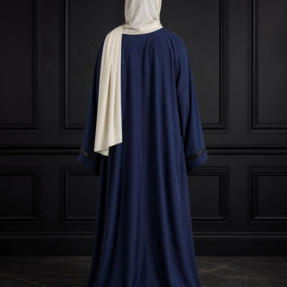 Model wearing premium navy closed nida abaya with attached inner and delicate lace sleeve detailing