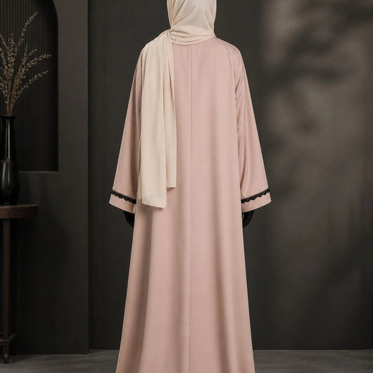 Model wearing premium nude beige closed nida abaya with attached inner and lace sleeve detailing