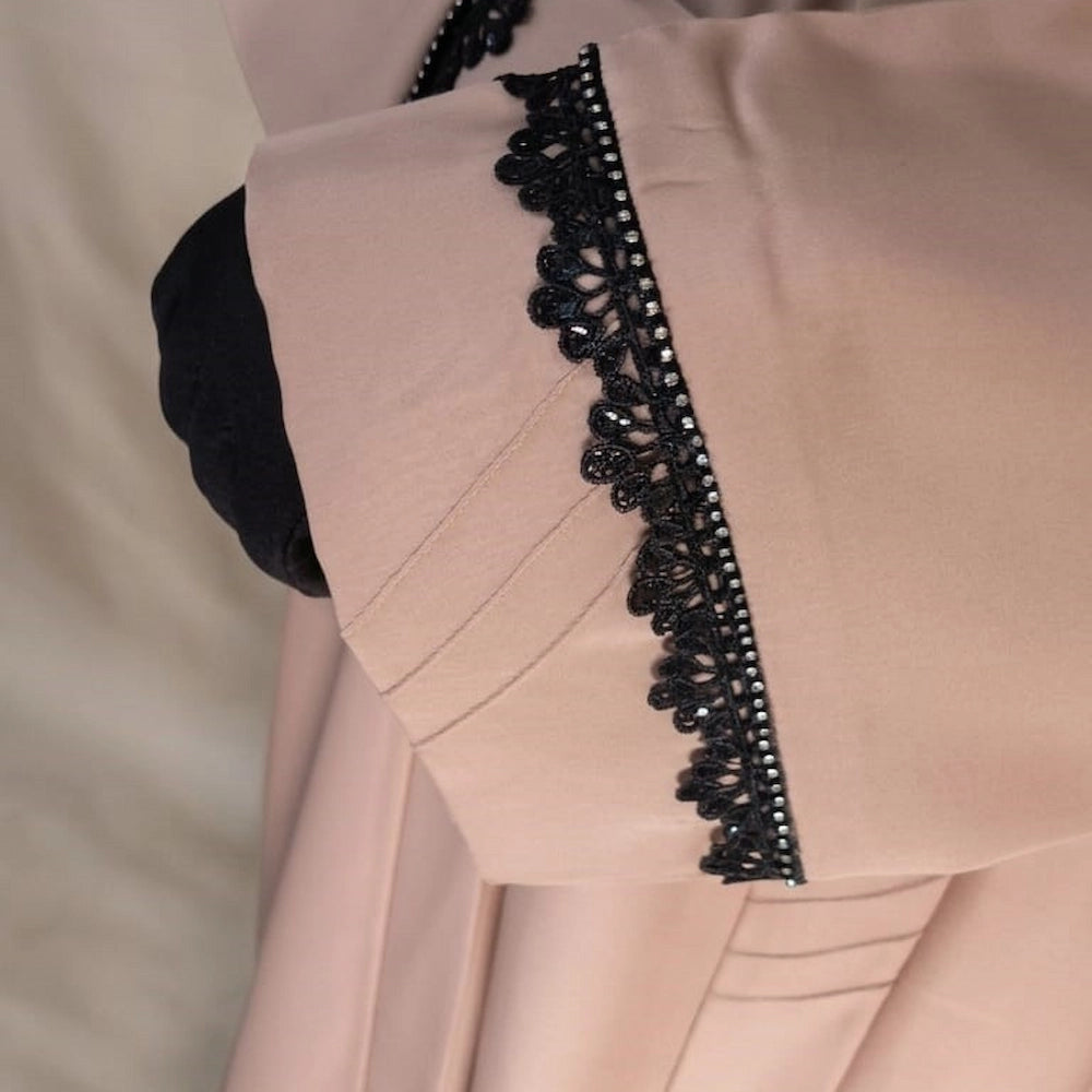 Model wearing premium nude beige closed nida abaya with attached  lace sleeve detailing