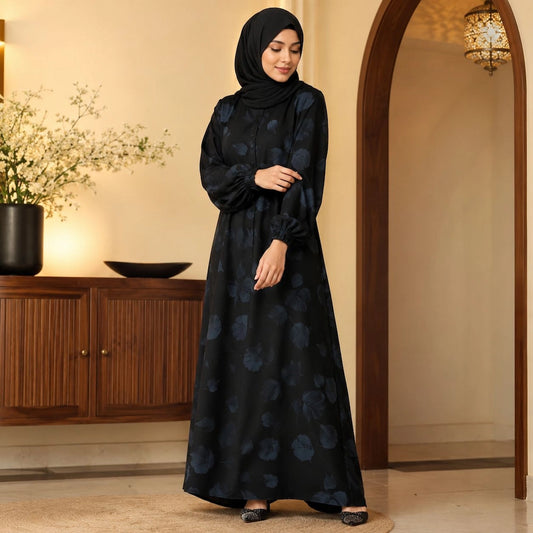 Woman wearing jet black floral abaya with subtle blue floral print, elastic cuffs and front buttons