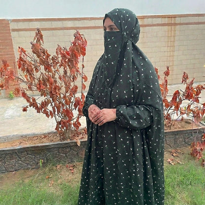 Woman in a black and green namaz chaddar