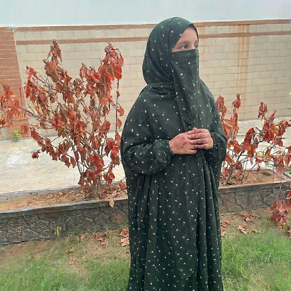 Young girl in a black and green flower namaz chaddar