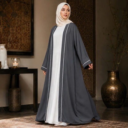 Woman wearing grey open front abaya with white piping and separate inner dress