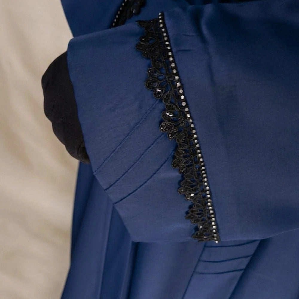 Model wearing premium navy closed nida abaya with attached inner and delicate lace sleeve detailing