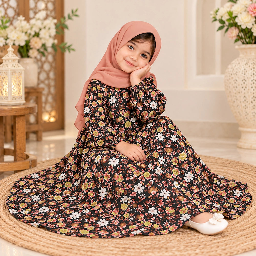 Girl wearing a black floral abaya with peach, yellow and white flowers, elastic cuffs and a peach hijab.