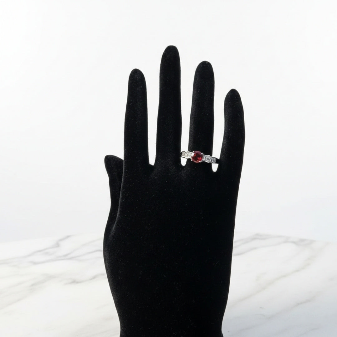 Silver ruby solitaire ring with diamond accent side stones, elegant luxury design
