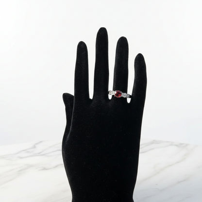 Silver ruby solitaire ring with diamond accent side stones, elegant luxury design
